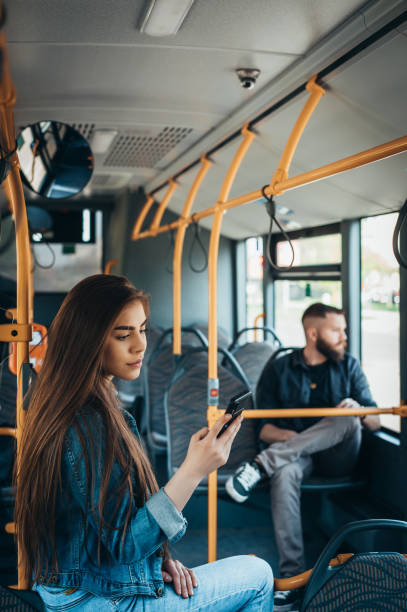 istock Young beautiful passengers using smartphones while riding the bus 1321884091