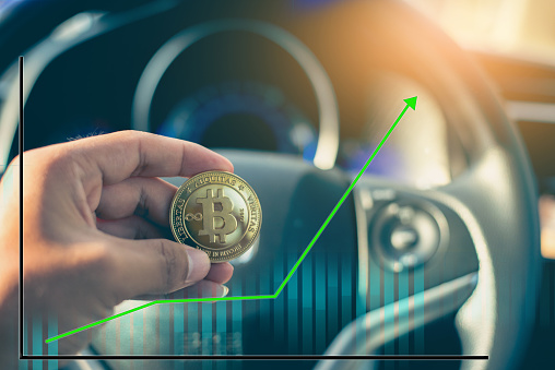 Bitcoin money and cars. Buying a car with cryptocurrency concept.
