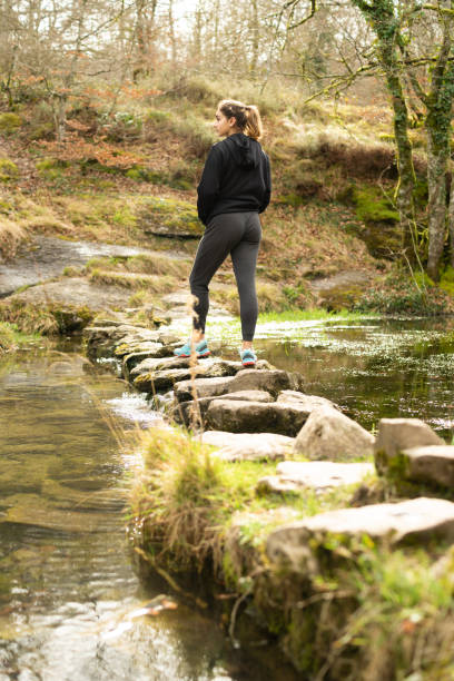 istock Hiker crossing a river on a rock truck 1321889252