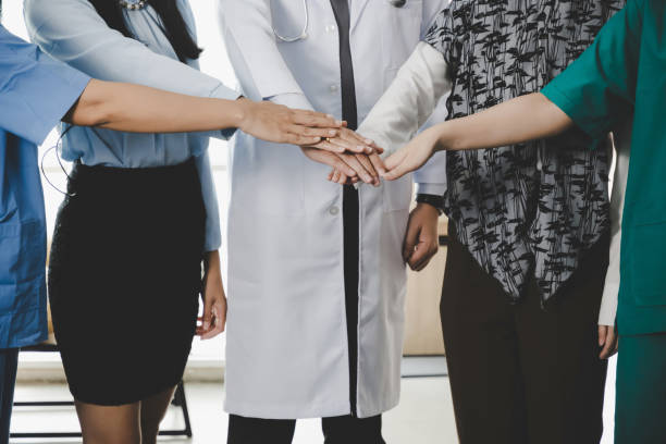istock Professional diversity people group stacking hands and standing together. Happy diverse hospital staff team stand in office, communication, occupation unity, medical and business teamwork concept 1321891120