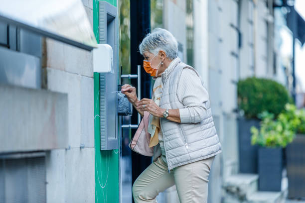 istock An Older Woman with Face Mask is Using ATM. 1321893553