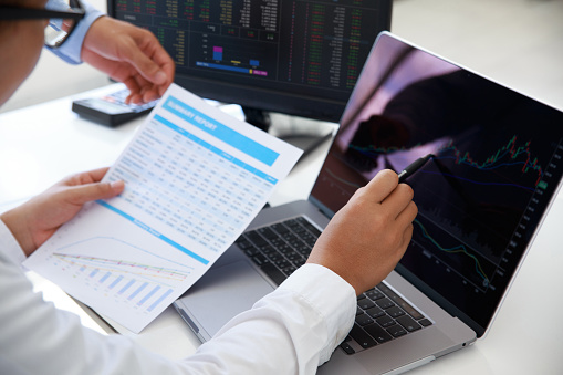 Close-up of young business team Investment Trading discussion and analysis finance market graph stock in office while man pointing on the data presented in the chart .Investment and stock chart concept. Depicts TradingView financial market chart.