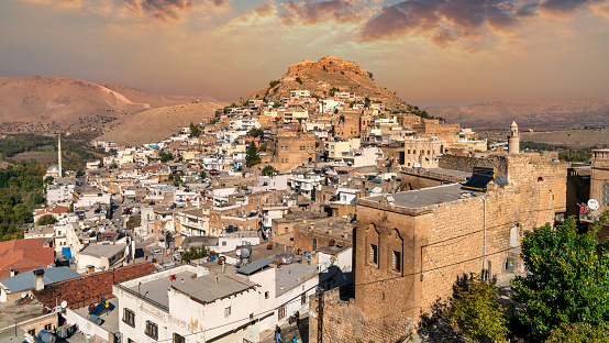 Savur, Mardin, Turkey - January 2020: Town of Savur with old stone houses on a hill with dramatic sky