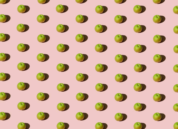 istock Bright fruit pattern with fresh organic green apples against pastel pink background. Creative summer vibes idea, minimalistic colorful concept. 1321898386