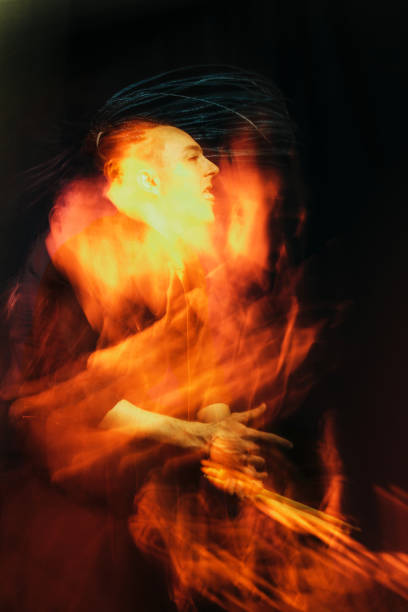 istock Handsome man with interesting braids on a black background with drumsticks, shot with mixed light 1321899768