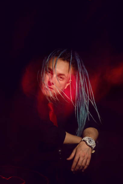 istock Handsome man with interesting braids on a black background, shot with mixed light 1321900008