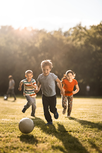 Niños jugando al fútbol al aire libre photo