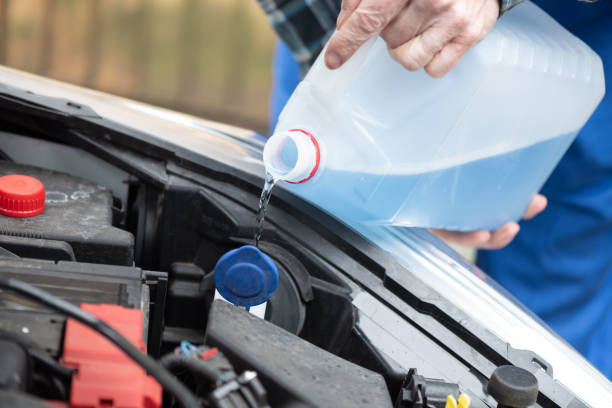 istock Hands of mechanic pouring windshield washer fluid in a car 1321902746