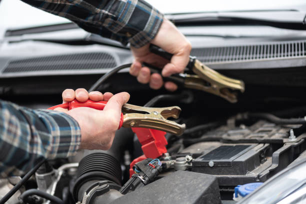 istock Car mechanic using car battery jumper cable 1321902875