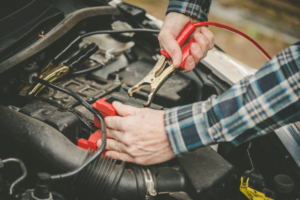 istock Hands of car mechanic using car battery jumper cable 1321903368