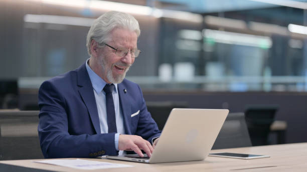 istock Successful Old Businessman Celebrating on Laptop at Work 1321908344