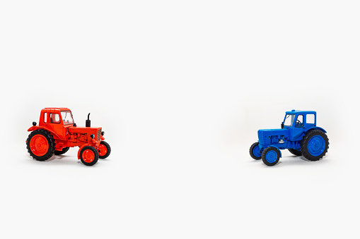 Two toy tractors realistic miniature replica on a white background. Layout for illustration and design of postcards. Copy space Isolate