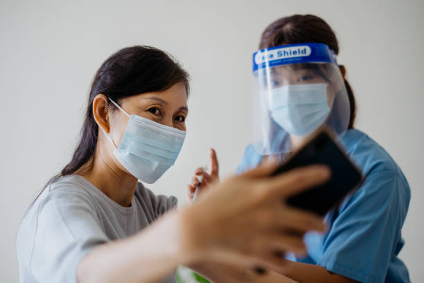 istock Woman taking selfie photo while getting a vaccine injection 1321913599