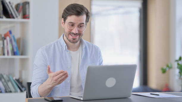istock Man in Glasses Talking on Video Call on Laptop 1321917575