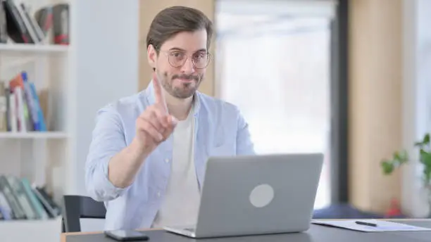 Photo of No Gesture with Finger by Man in Glasses in Office