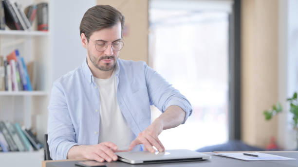 istock Man in Glasses Coming Back and Opening Laptop 1321917632