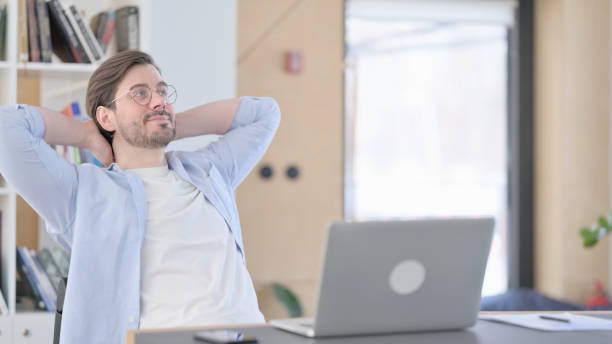 istock Happy Man in Glasses with Laptop Relaxing in Office 1321917742
