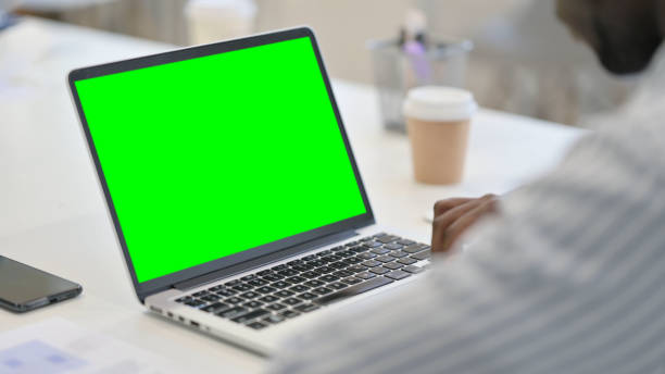 istock African Man using Laptop with Green Chroma Key Screen 1321919351
