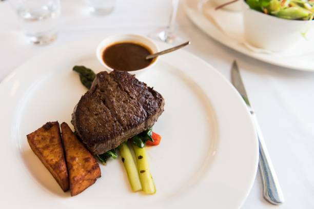 istock white plate with steak, asparagus, potato and gravy. 1321919849