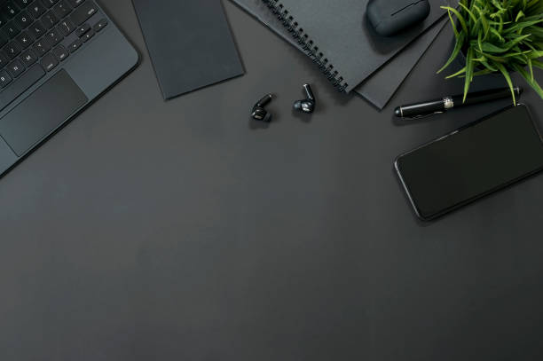 istock workspace with smartphone, tablet keyboard and gadget on black background. 1321920836