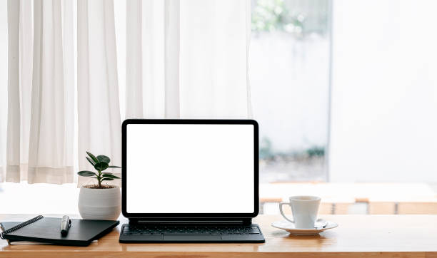 istock Blank screen talet with keyboard on wooden table in modern living room. 1321922017