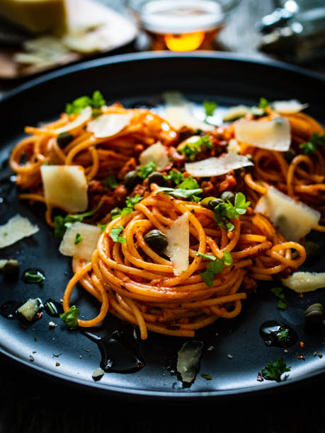 istock Spaghetti bolognese - pasta with minced pork and tomato sauce on black table 1321926528