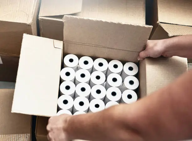 Box full of paper rolls for the printout of a cash register.