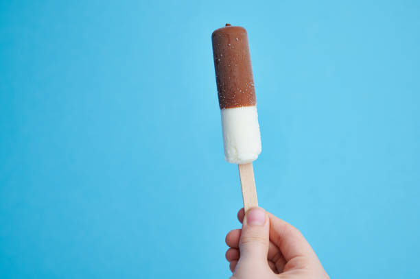 istock vanilla ice cream stick on blue background with copy space 1321931238