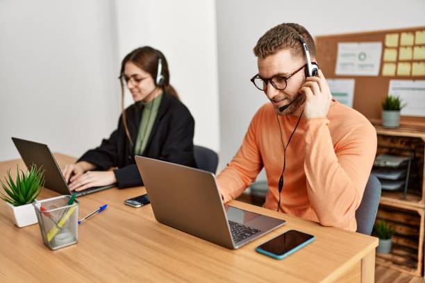istock Two caucasian call center agents working at the office. 1321931431