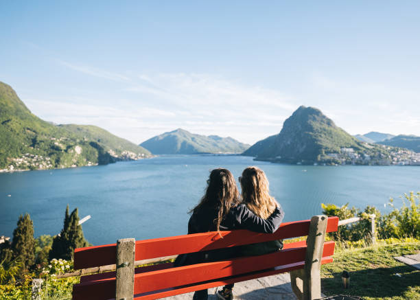 istock Young women relax at lakefront viewpoint 1321931715