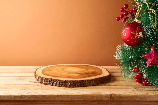 istock Empty wooden log board on rustic table with Christmas tree. Christmas background for mock up design 1321931722