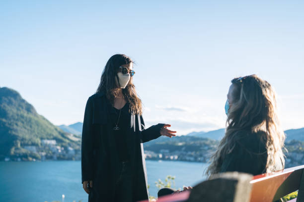 istock Young women wearing protective face masks relax at viewpoint 1321932167