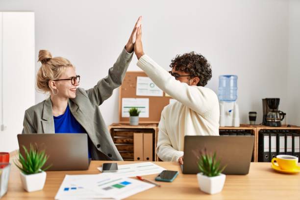 istock Two business executives raised up hands hitting five at the office. 1321932184