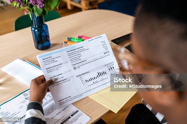 A Young Woman Looks At The Electricity Bill Stock Photo - Download Image Now - Financial Bill, Electricity, Energy Bill