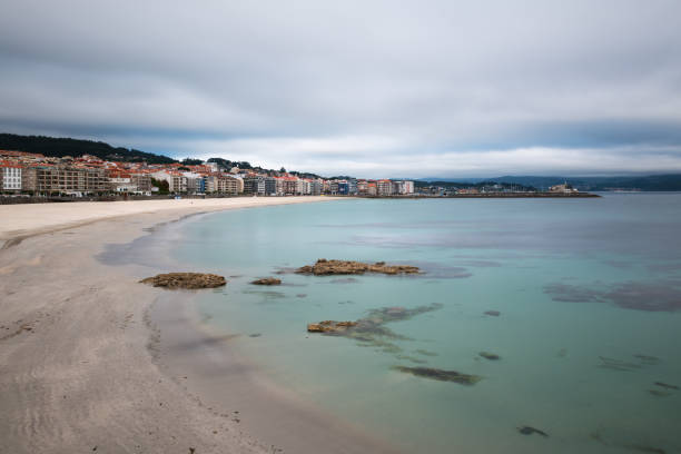 Panorama view of Sanxenxo and Silgar beach at the end of a cloudy Spring day in the Rias Baixas in Galicia, Spain. Long exposure.