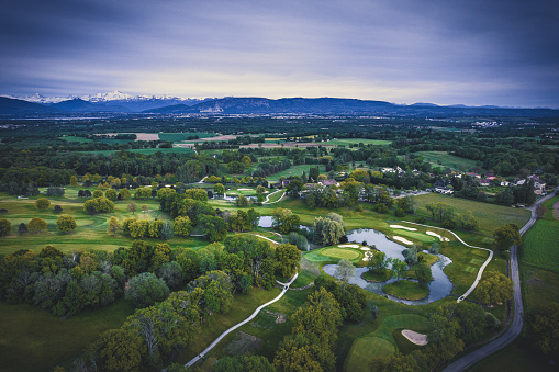 Aerial view of a golf course and the Alps in the Pays de Gex near Geneva, Ain, France