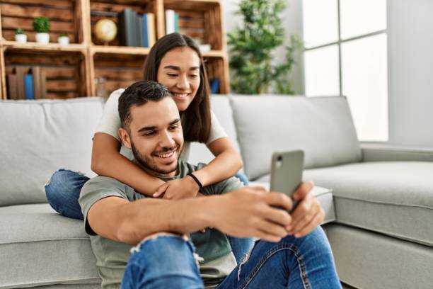 Young latin couple smiling happy making selfie by the smartphone at home. Young latin couple smiling happy making selfie by the smartphone at home. iberian ethnicity stock pictures, royalty-free photos & images