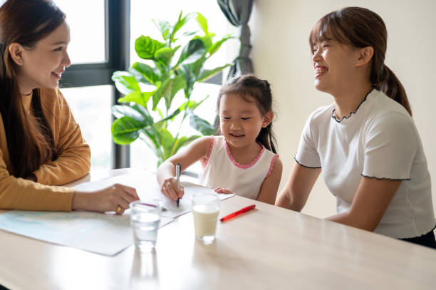 Professional child psychologist talking with child girl in office with kids mother An Asian professional child psychologist talking with child girl in office, child draws a drawing. parent counseling stock pictures, royalty-free photos & images