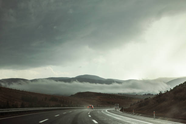 carretera en tiempo tormentoso con cielo dramático - freedom cloud cloudscape meteorology fotografías e imágenes de stock