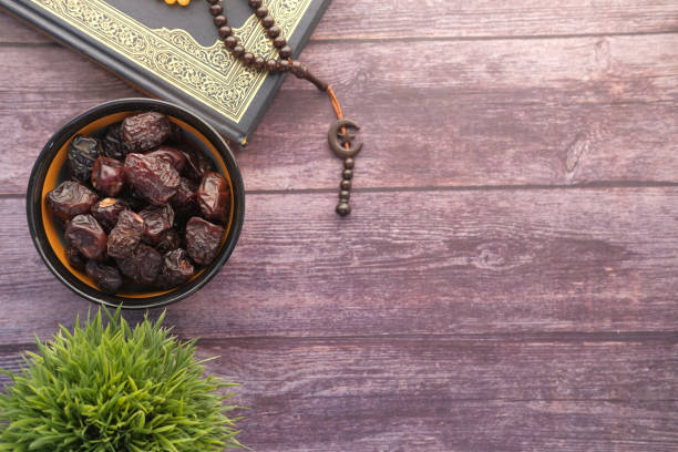 istock Holy book Quran, prayer beads and date fruit on table with copy space 1321944139