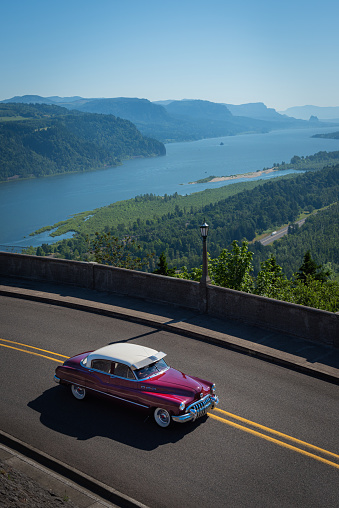 A classic American car on a scenic summer road