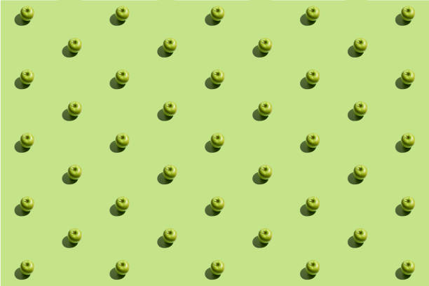 istock Minimal repetitive pattern made of green appes on green background 1321946686