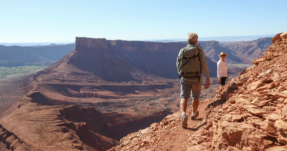 They look off to desert landscape surrounding