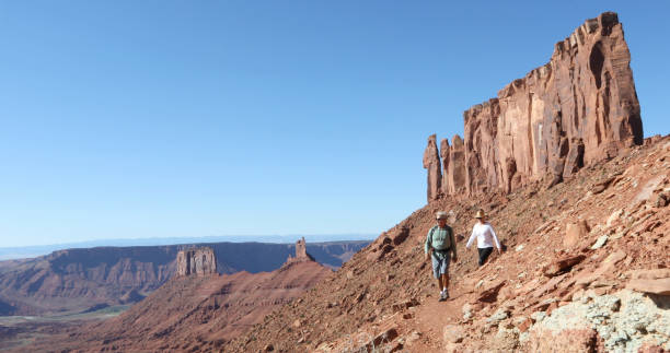 istock Mature couple hike along sunny mountain ridge 1321956012