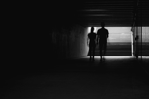 silhouettes of people in the dark tunnel