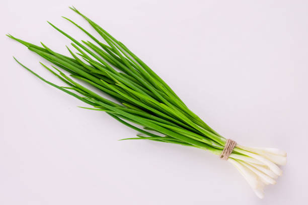 A bunch of  green onions on a white background. Flat lay.
