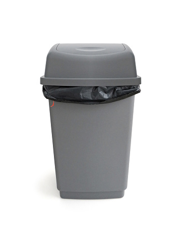 Front view of trash can with bag isolated on white background. Close up of gray plastic trash can. Black plastic bag in gray trashcan bin with lid. Household garbage. Recycling container.