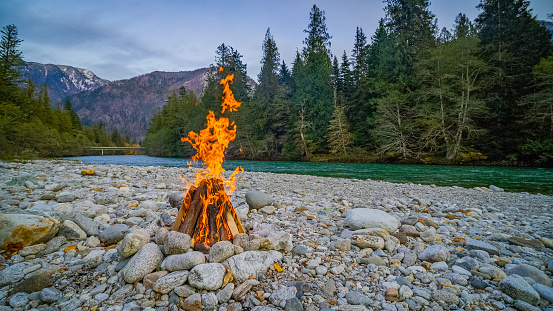 Campfire on the river bank. Transparent river in the mountain forest. Skagit river loop trail, North Cascades