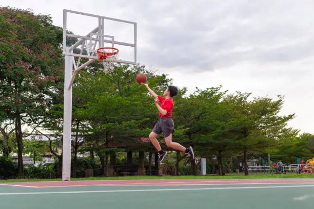 Outdoor urban basketball training session for individual young male streetball player