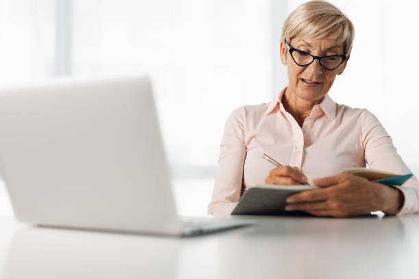 istock Senior  businesswoman taking notes in the office 1321967085